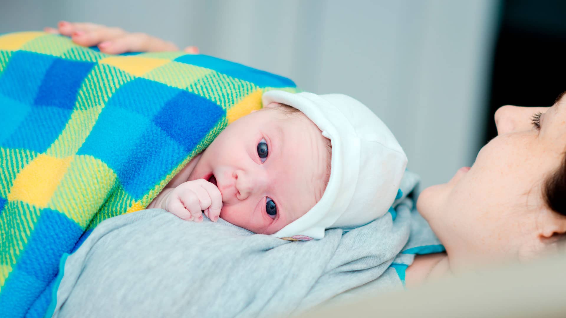 bebê coberto no colo da mãe AME (Atrofia Muscular Espinhal)